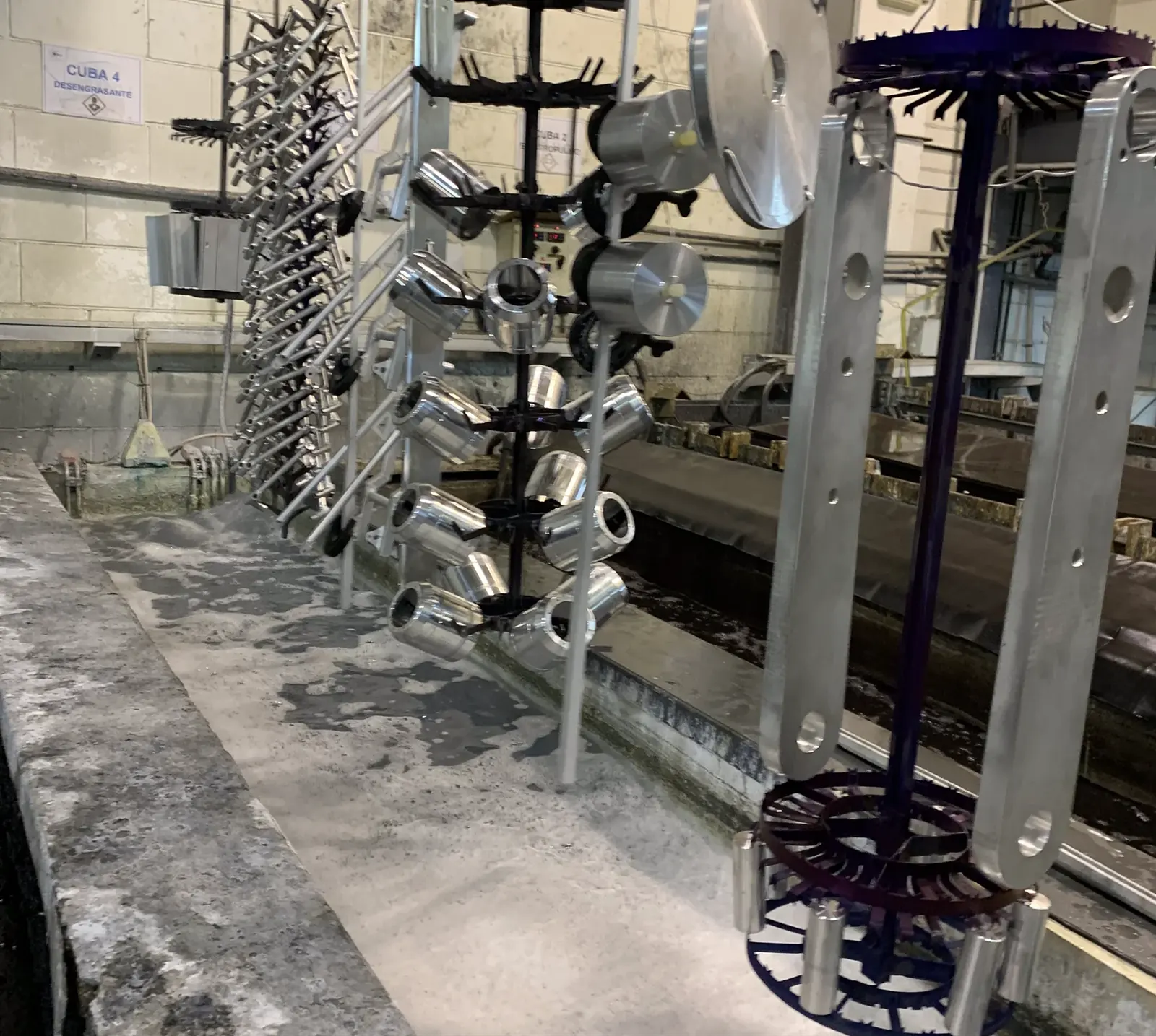 Bastidores con piezas de aluminio colgadas antes de entrar en la línea