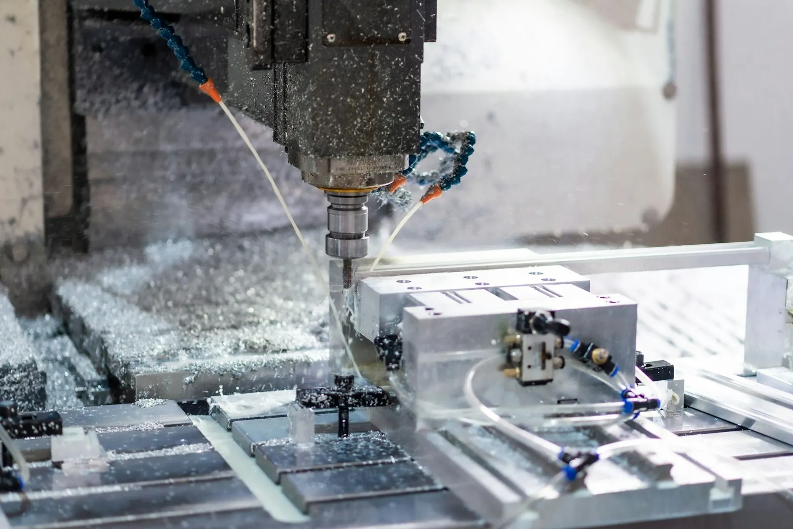 Fresadora CNC mecanizando un bloque de aluminio entre virutas
