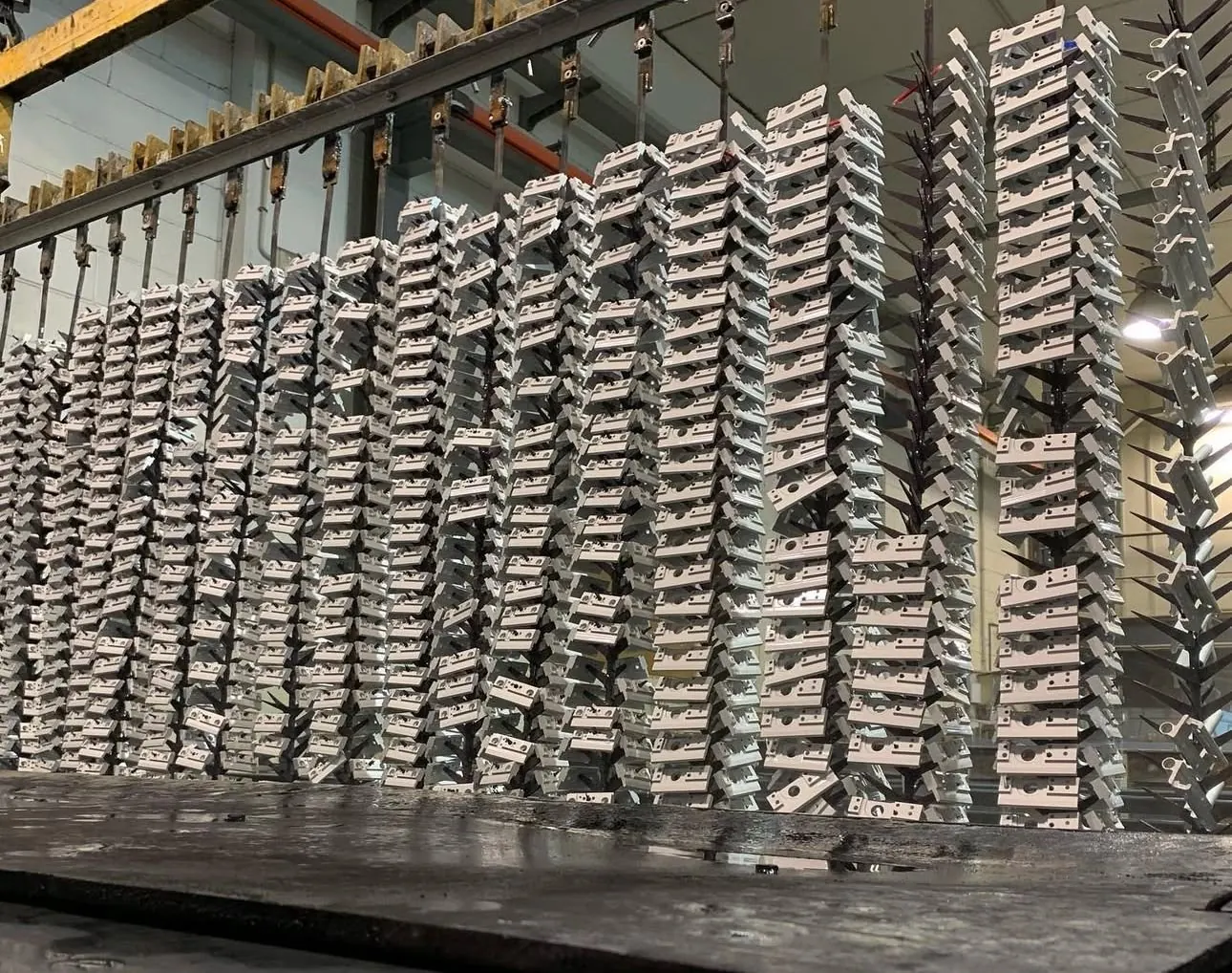 Cientos de piezas de aluminio en bastidores, listas para el tratamiento
